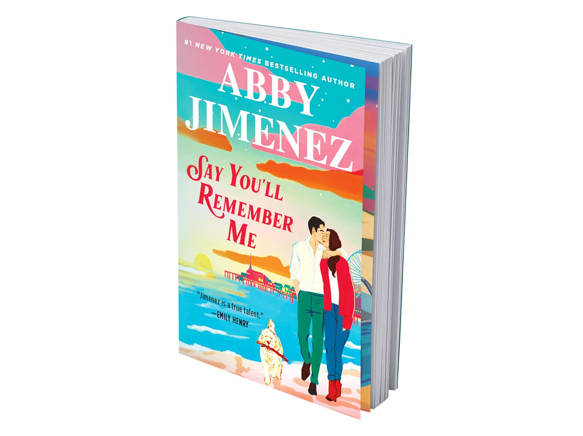 book with side pages displayed for Say You'll Remember Me by Abby Jimenez featuring a couple on the beach with a dog holding a stick and a ferris wheel in the background