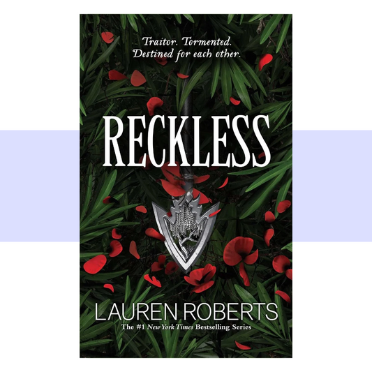 Book cover for Reckless by Lauren Roberts. The cover features a deep forest-green and nearly black background, layered with long, pointed green leaves and scattered vivid red petals. A silver dagger-shaped pendant hangs vertically in the center, its ornate handle and blade creating a striking focal point beneath the title. “RECKLESS” appears across the upper-middle area in very large, tall white serif capital letters. Above the title, smaller white text reads, “Traitor. Tormented. Destined for each other.” 